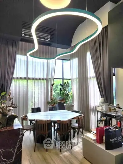 Stylish dining area with modern lighting and large windows in a contemporary home.