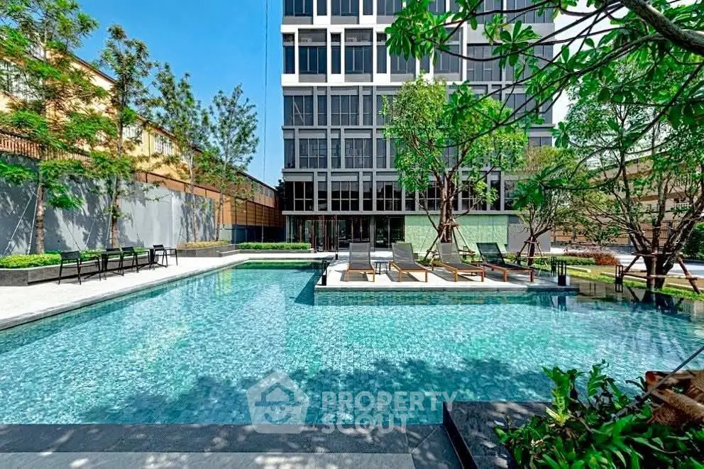 Luxurious modern apartment complex with stunning outdoor pool and lush greenery.