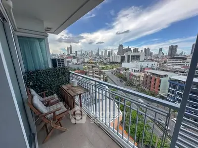 Stunning city view from a modern balcony with cozy seating area.