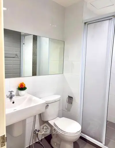 Modern bathroom with sleek fixtures and a glass shower door.