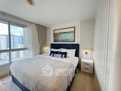 Luxurious bedroom with modern decor and large window offering city views.