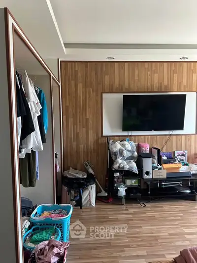 Cozy living room with wooden paneling and wall-mounted TV