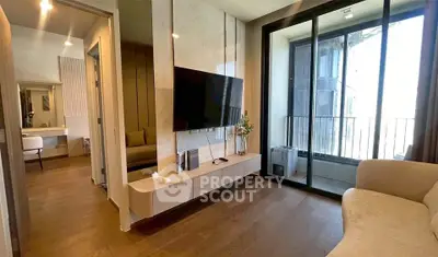 Modern living room with sleek design and balcony view, featuring a wall-mounted TV and elegant furnishings.