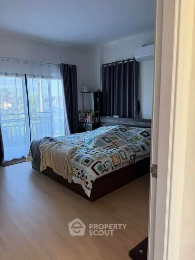 Cozy bedroom with modern decor and large windows for natural light.