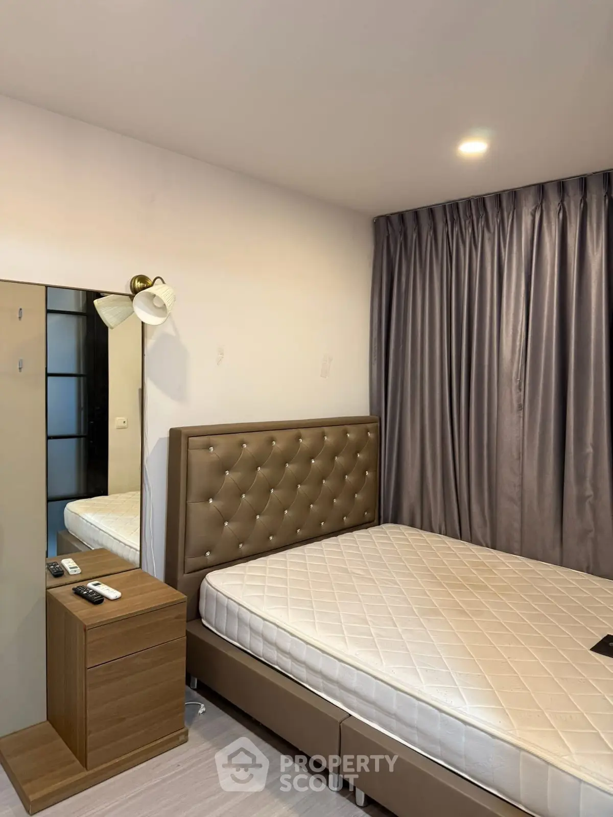 Cozy bedroom with elegant tufted headboard and modern lighting, perfect for restful nights.