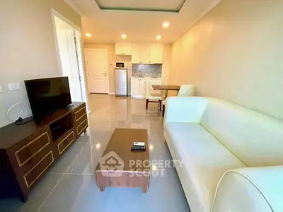 Modern living room with sleek furniture and open kitchen layout in a bright apartment.
