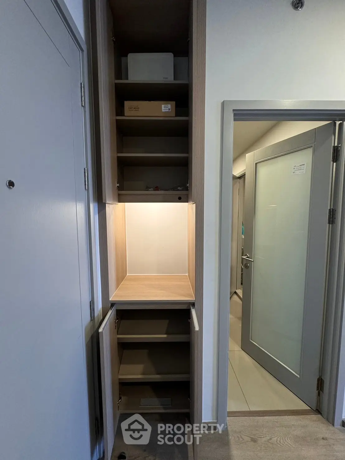 Modern storage cabinet in a sleek apartment hallway with ample shelving and minimalist design.