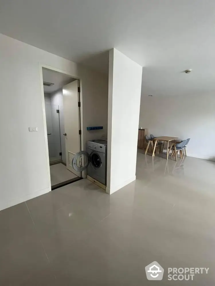 Modern apartment interior with washing machine and dining area