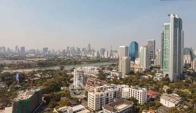 Stunning cityscape view showcasing modern skyscrapers and lush greenery by the river.