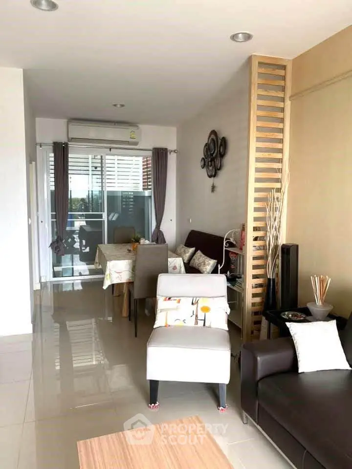 Modern living room with dining area and balcony access, featuring stylish decor and ample natural light.
