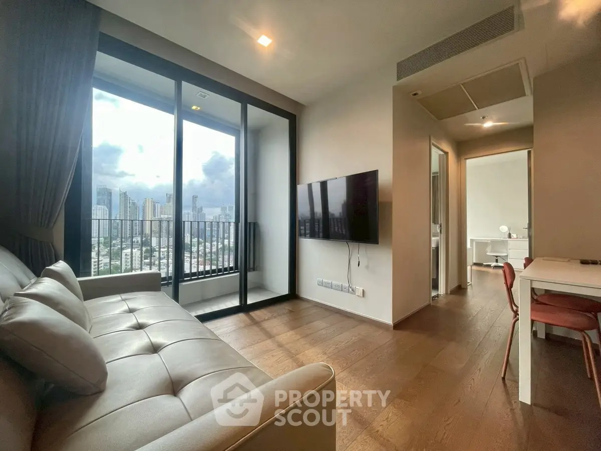 Modern living room with city view, featuring sleek furniture and large windows for natural light.
