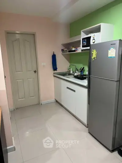 Modern kitchen with sleek appliances and vibrant green accent wall, perfect for culinary enthusiasts.