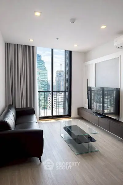 Modern living room with sleek furniture and city view from large window.