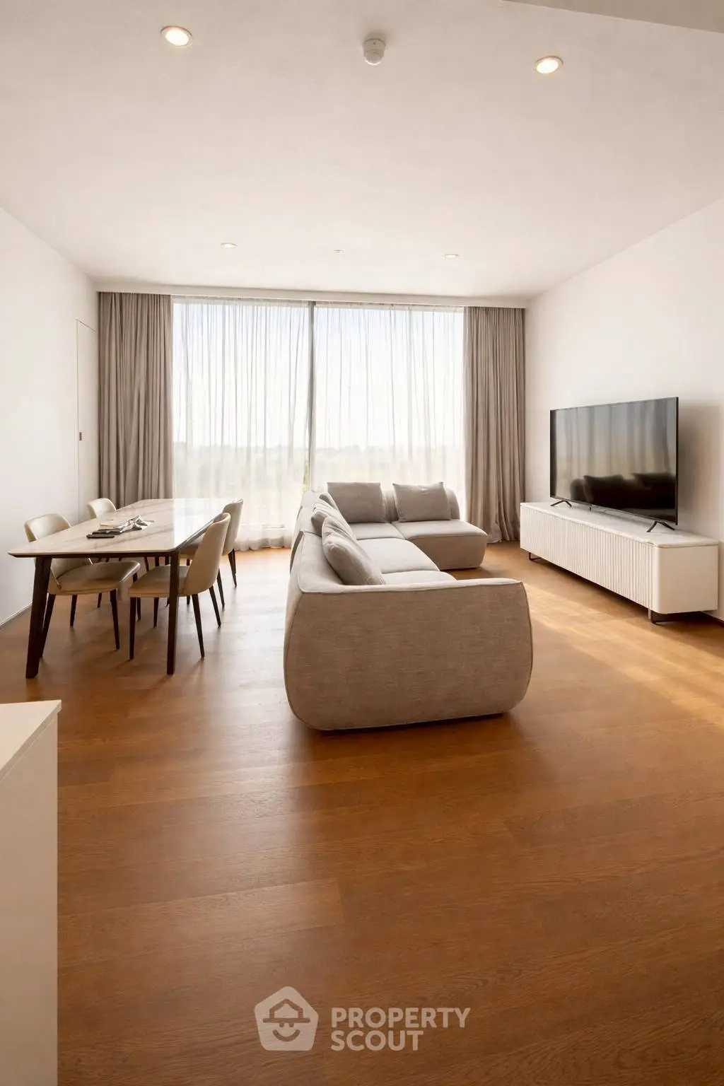 Spacious modern living room with elegant furniture and large windows offering natural light.