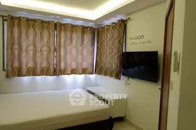 Cozy bedroom with modern decor and wall-mounted TV, featuring elegant curtains and ambient lighting.