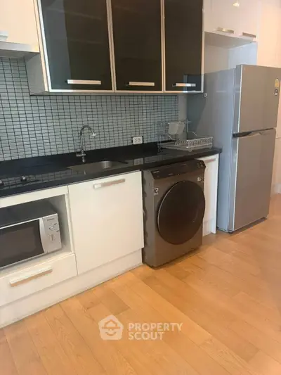 Modern kitchen with sleek appliances and wooden flooring
