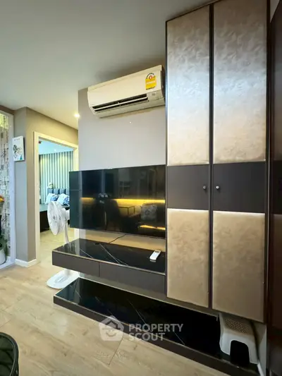Modern living room with sleek TV unit and air conditioning, featuring elegant wood flooring and stylish decor.