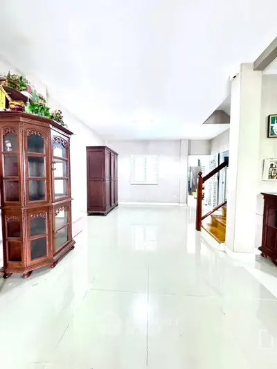 Spacious interior with elegant wooden cabinets and glossy tiled flooring, perfect for a stylish home.