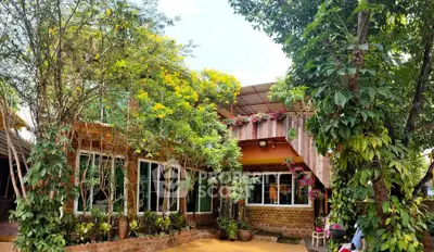 Charming rustic house with lush garden and vibrant flowers, perfect for nature lovers seeking tranquility.