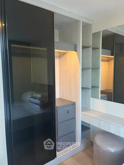 Modern bedroom with sleek wardrobe and vanity area, featuring ample storage and contemporary design.