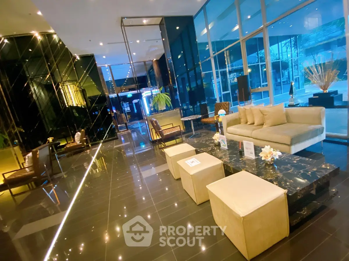 Luxurious modern lobby with elegant seating and glass walls in upscale building.
