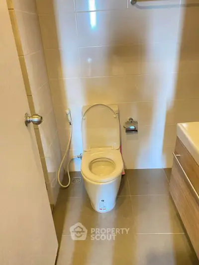 Modern bathroom with sleek toilet and tiled walls in a compact space.