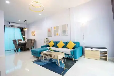 Modern living room with stylish blue sofa and dining area in open layout