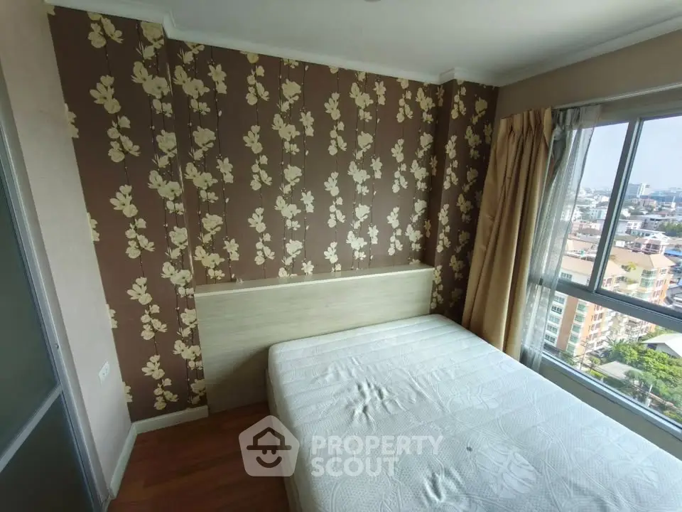 Cozy bedroom with floral wallpaper and city view from large window