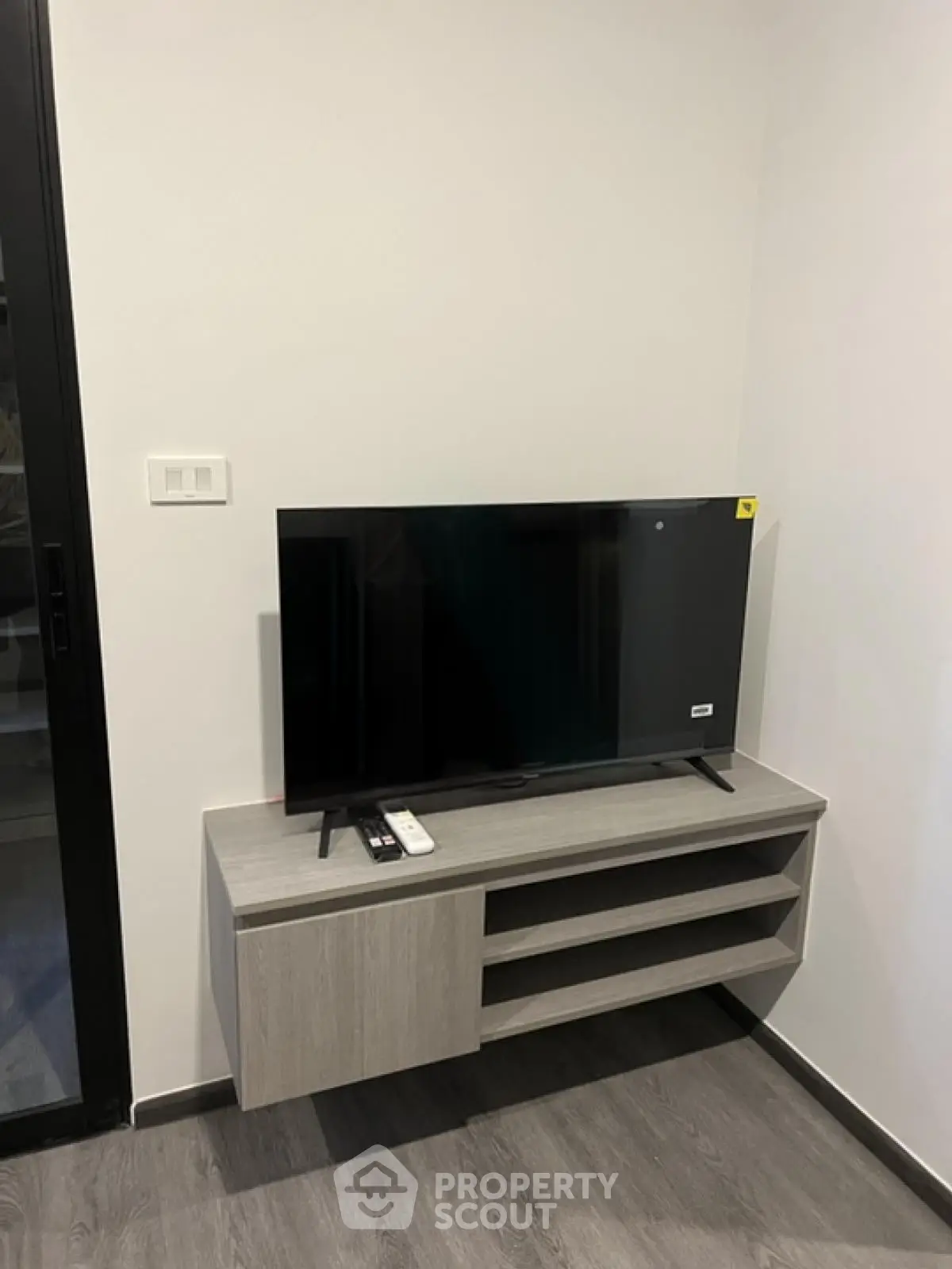 Modern living room with sleek TV stand and flat-screen TV, perfect for entertainment setup.
