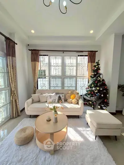 Charming living room with festive decor, cozy seating, and large windows for natural light.