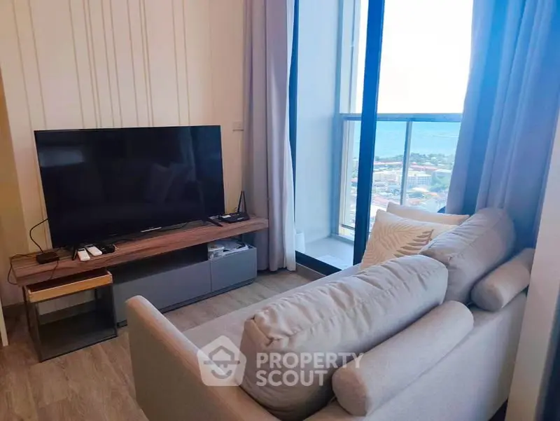 Modern living room with cozy sofa and stunning ocean view from balcony.