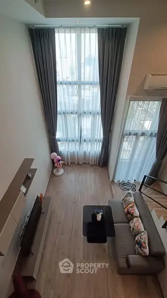 Spacious modern living room with high ceilings and large windows offering abundant natural light.