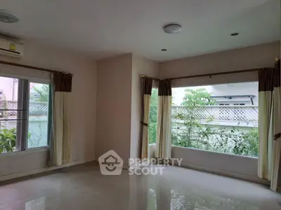 Spacious empty room with large windows and garden view, perfect for customization.