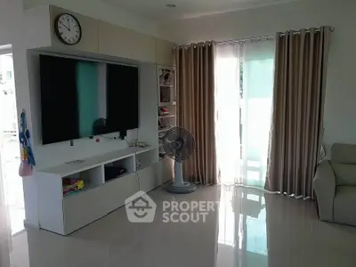 Spacious living room with modern TV setup and natural light