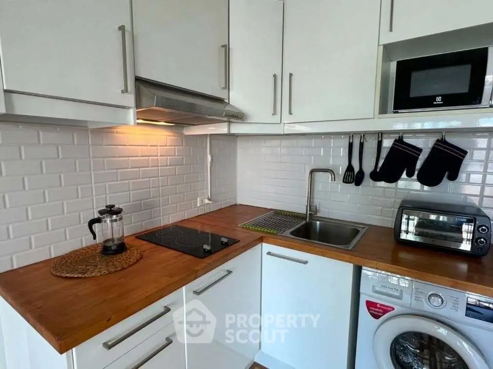 Modern kitchen with wooden countertops, white cabinets, and built-in appliances for a sleek urban lifestyle.