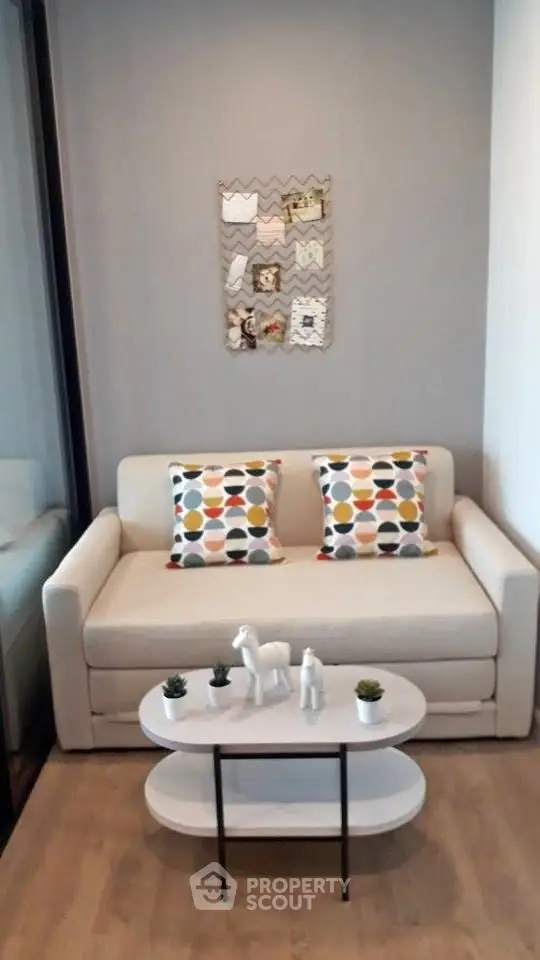 Cozy living room with modern sofa and stylish decor in a compact space.