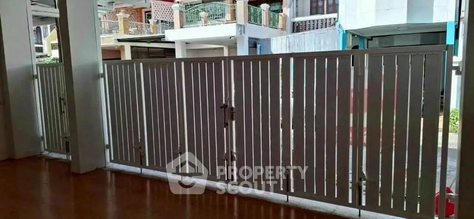 Modern gated entrance with sleek metal design in urban residential area.