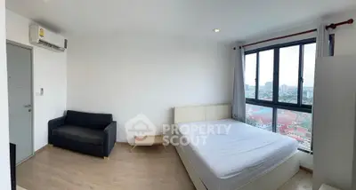Bright and airy bedroom with city view, featuring modern furnishings and large windows.
