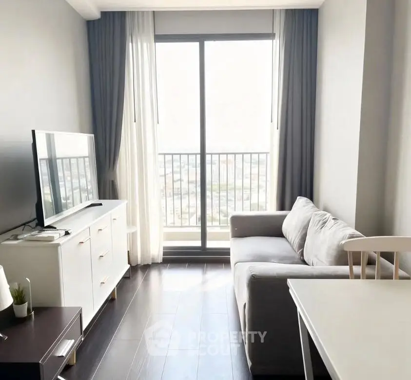 Modern living room with sleek furniture and large window offering city view.
