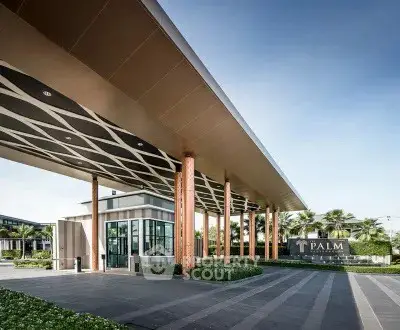 Modern building entrance with sleek design and lush landscaping