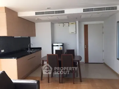Modern kitchen and dining area with sleek cabinetry and integrated appliances in a stylish apartment.