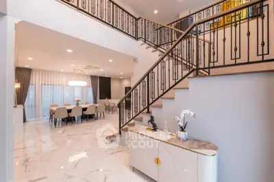Luxurious open-plan living area with elegant staircase and modern dining space.