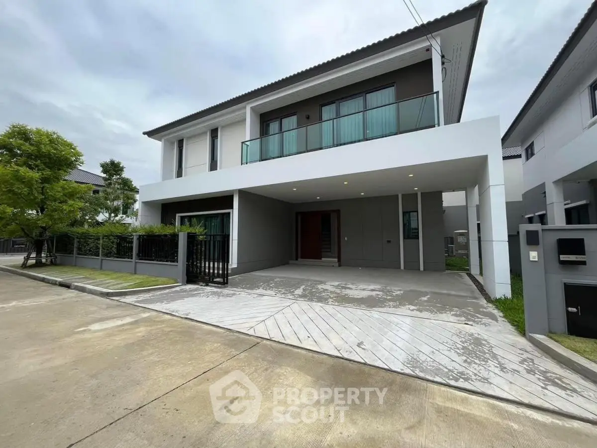 Modern two-story house with spacious driveway and balcony in suburban neighborhood
