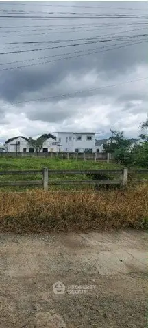 Scenic view of a countryside property with a white house and lush greenery.
