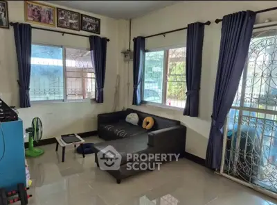 Cozy living room with sectional sofa and large windows, perfect for relaxation and natural light.