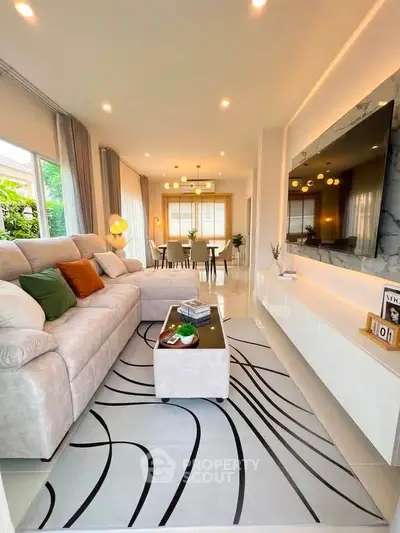 Elegant living room with modern decor, plush sofa, and stylish lighting in a bright open layout.