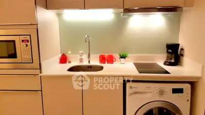 Modern kitchen with sleek appliances and integrated washing machine