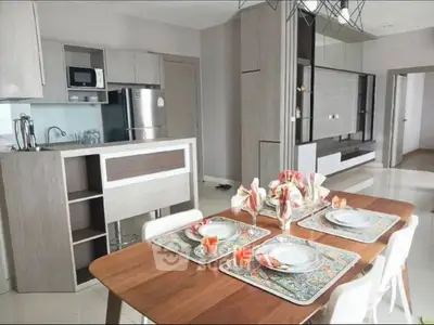 Modern dining area with stylish kitchen featuring stainless steel appliances and elegant decor.