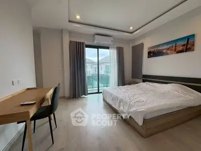 Spacious bedroom with modern decor and balcony access in a stylish apartment.