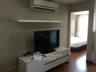Modern living room with sleek TV setup and air conditioning in a stylish apartment.